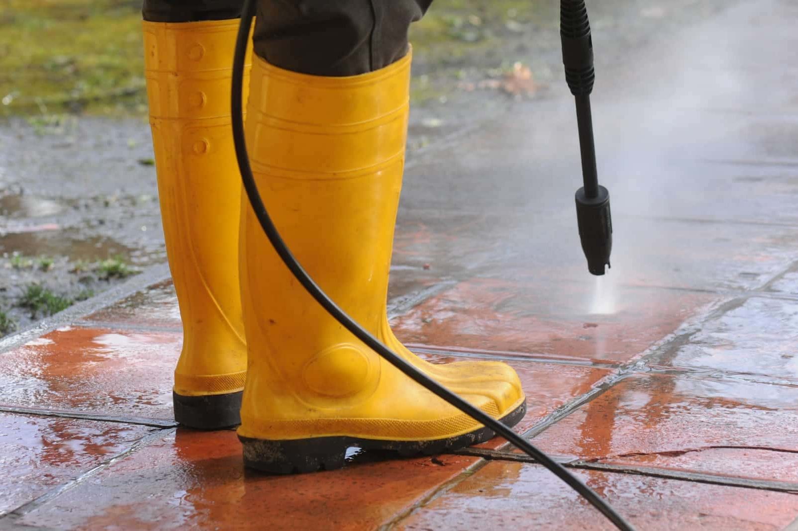 cropped-personne-portant-bottes-caoutchouc-jaune-buse-eau-haute-pression-nettoyant-salete-dans-carreaux-1.jpg nettoyage extérieur Alsace